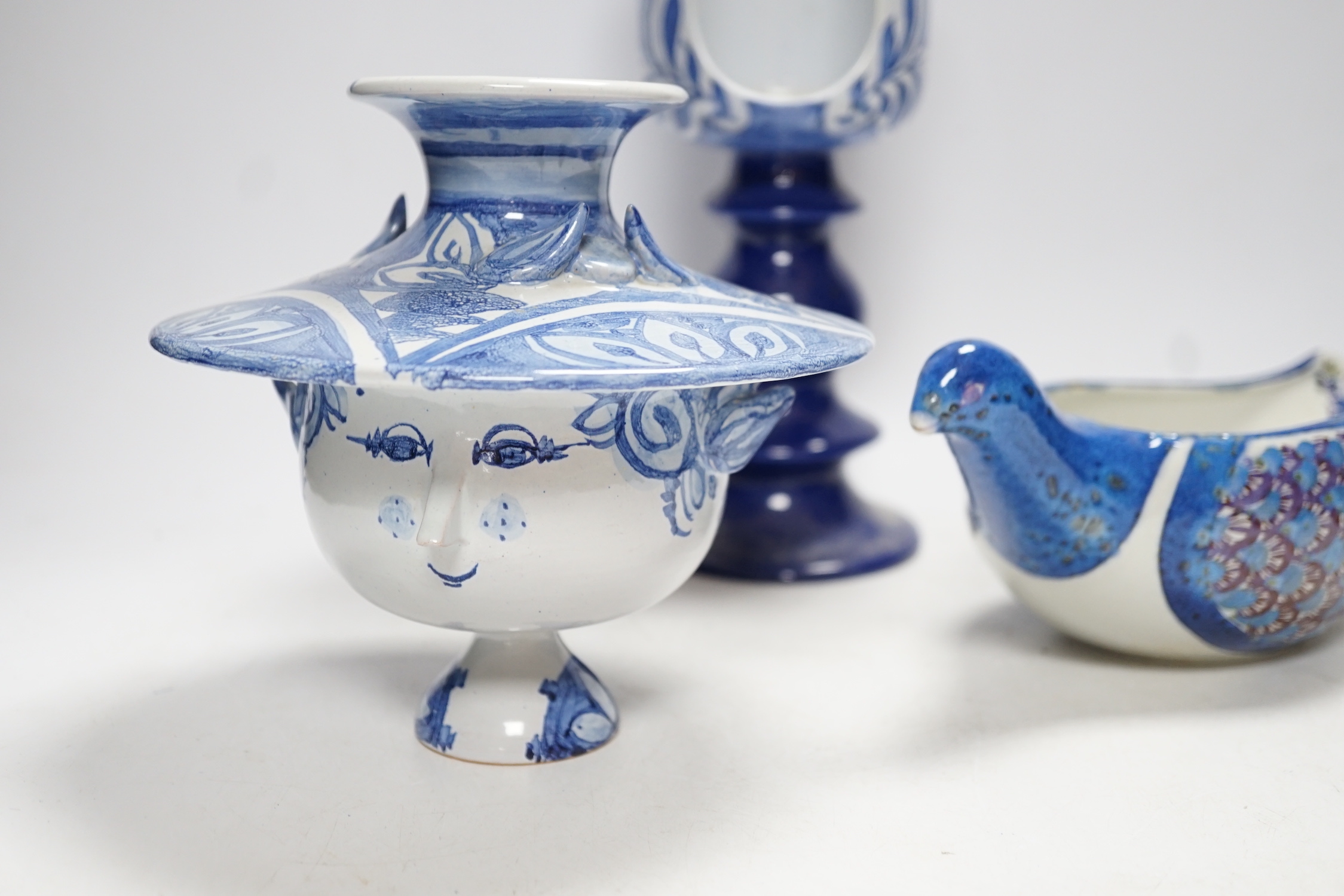 Two Danish ceramic items designed by Bjorn Wiinblad; a lidded pedestal cup in the form of a head with large hat and a candlestick, 26cm high, together with a bird sauce boat signed BJ on base (Berte Jesson)